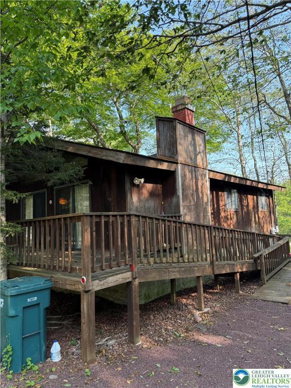 9817 Deerwood Dr, Coolbaugh Twp, PA 18466 - rear view of property featuring a chimney and a deck