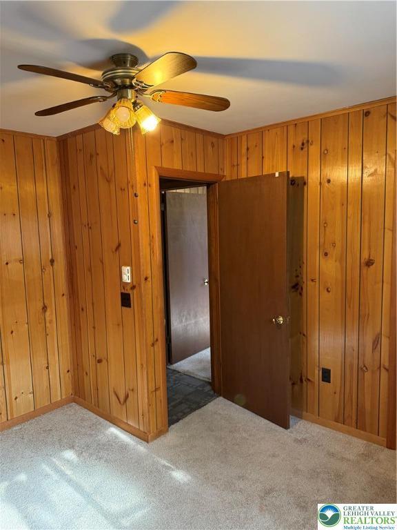 9817 Deerwood Dr, Coolbaugh Twp, PA 18466 - carpeted spare room with a ceiling fan and wood walls