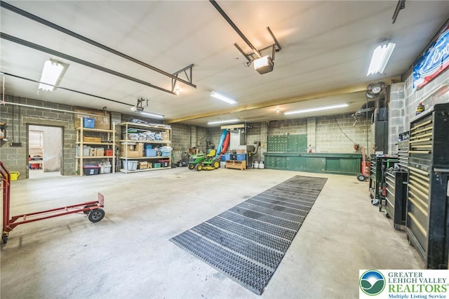 2922 Dogwood Dr, Coopersburg Boro, PA 18036 - garage featuring a garage door opener, concrete block wall, and a workshop area