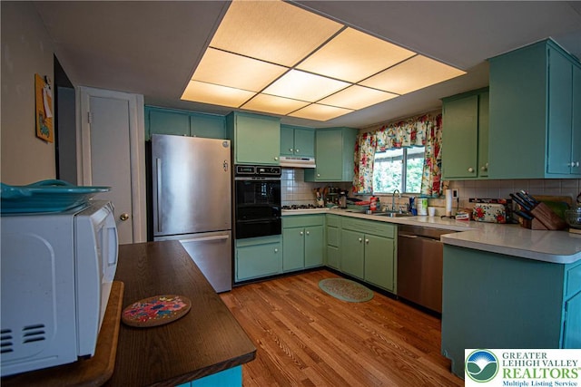1208 E Susquehanna St, Salisbury Twp, PA 18103 - kitchen featuring appliances with stainless steel finishes, green cabinetry, under cabinet range hood, a warming drawer, and wood finished floors