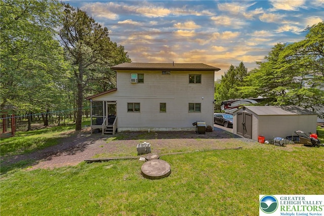 179 Chippewa Trl, Penn Forest Twp, PA 18210 - back of property at dusk featuring a sunroom and a shed