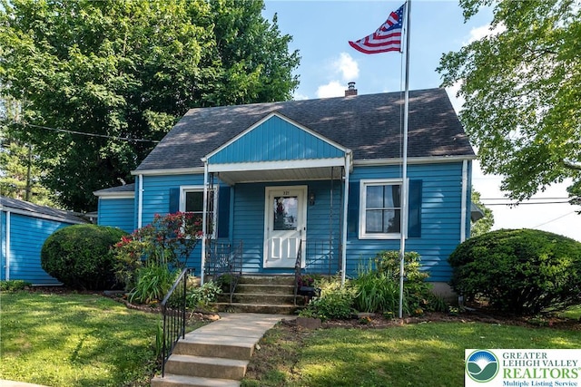 321 Willow Rd, Hellertown Borough, PA 18055 - bungalow-style home with a front lawn, covered porch, a chimney, and a shingled roof
