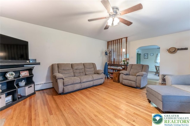 1571 Penn Dr, West Penn Twp, PA 18211 - living area with arched walkways, baseboard heating, a ceiling fan, and wood finished floors