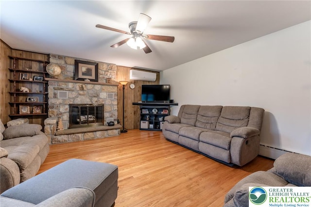 1571 Penn Dr, West Penn Twp, PA 18211 - living area with an AC wall unit, ceiling fan, a baseboard heating unit, and wood finished floors