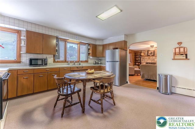1571 Penn Dr, West Penn Twp, PA 18211 - kitchen with freestanding refrigerator, arched walkways, a baseboard heating unit, light countertops, and decorative backsplash