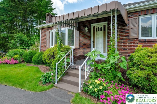 1571 Penn Dr, West Penn Twp, PA 18211 - view of exterior entry featuring brick siding and a chimney