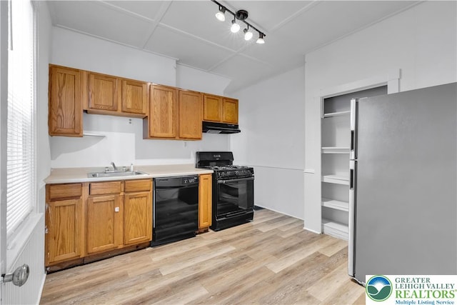 834 Bushkill St, Easton, PA 18042 - kitchen featuring black appliances, under cabinet range hood, light wood-style floors, light countertops, and rail lighting