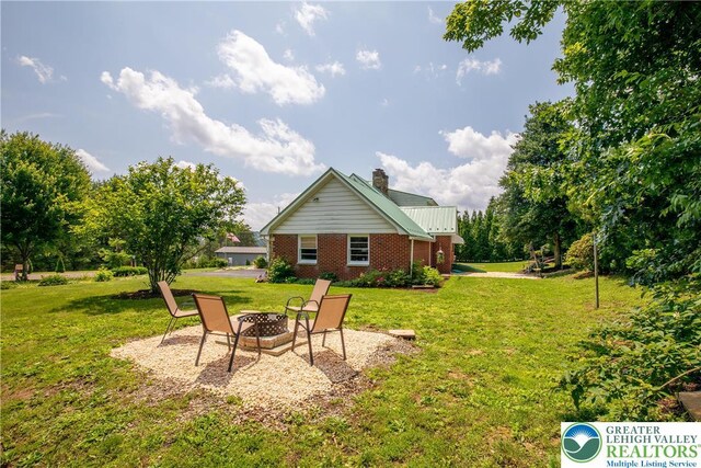 7035 Scenic Dr, Bloomsburg, PA 17815 - back of house featuring a chimney, brick siding, a yard, and a fire pit
