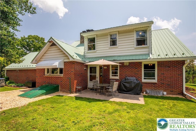 7035 Scenic Dr, Bloomsburg, PA 17815 - rear view of house featuring brick siding, a lawn, a patio, and a metal roof