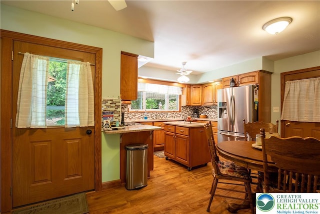 7035 Scenic Dr, Bloomsburg, PA 17815 - kitchen with stainless steel fridge with ice dispenser, ceiling fan, light countertops, light wood-style floors, and tasteful backsplash