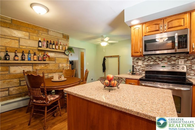 7035 Scenic Dr, Bloomsburg, PA 17815 - kitchen with stainless steel appliances, baseboard heating, ceiling fan, wood finished floors, and tasteful backsplash