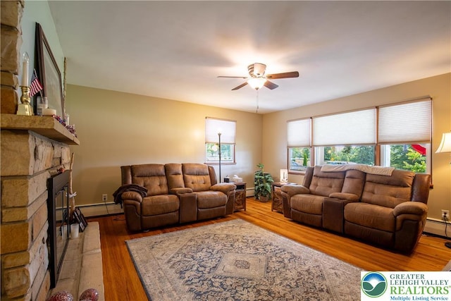 7035 Scenic Dr, Bloomsburg, PA 17815 - living room with ceiling fan, wood finished floors, a fireplace, and a baseboard heating unit