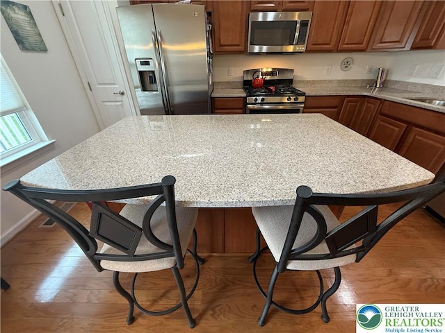 23 Yellow Rose Ln, Easton, PA 18045 - kitchen with stainless steel appliances, a breakfast bar area, and brown cabinetry