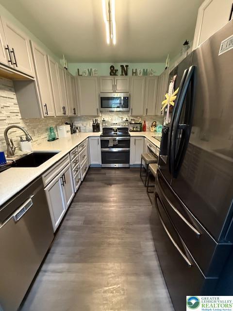2413 Walbert, South Whitehall Twp, PA 18104 - kitchen with appliances with stainless steel finishes, light countertops, tasteful backsplash, and dark wood-style floors