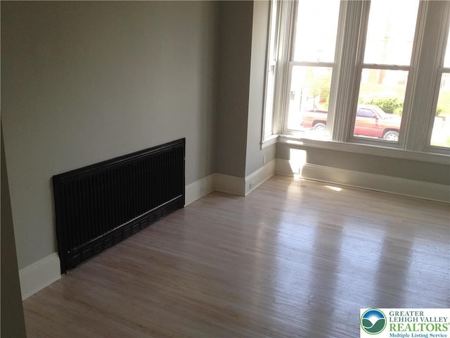 1002 Lehigh St, Easton, PA 18042 - empty room with radiator heating unit, plenty of natural light, and wood finished floors