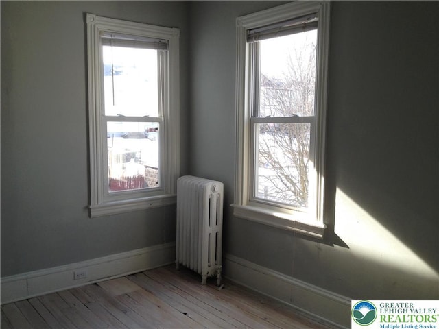 1002 Lehigh St, Easton, PA 18042 - empty room with radiator, plenty of natural light, and wood finished floors