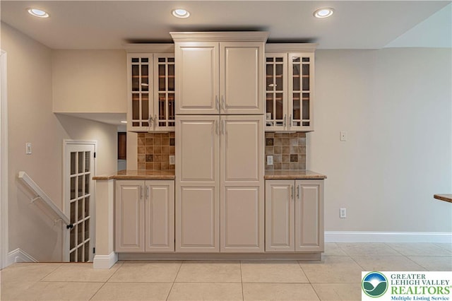 1450 Coventry Rd, South Whitehall Twp, PA 18104 - kitchen with recessed lighting, decorative backsplash, glass insert cabinets, light tile patterned flooring, and light stone counters
