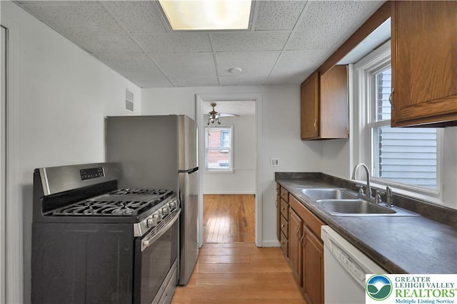 1509 Liberator Ave, Allentown City, PA 18103 - kitchen featuring stainless steel range with gas cooktop, dishwasher, light wood-style flooring, brown cabinets, and dark countertops