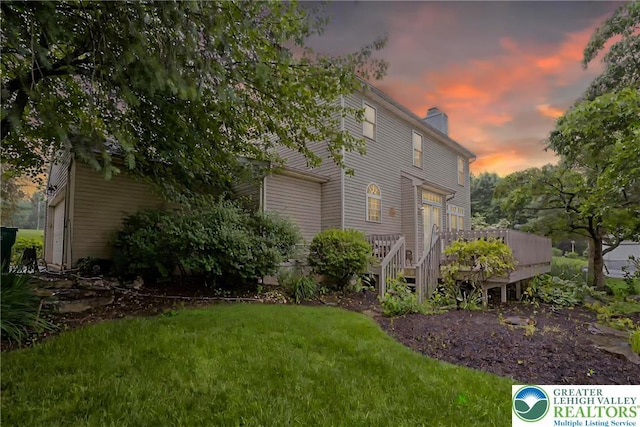5900 Wayside Dr, Lower Macungie Twp, PA 18062 - property exterior at dusk with a chimney, a wooden deck, and a yard