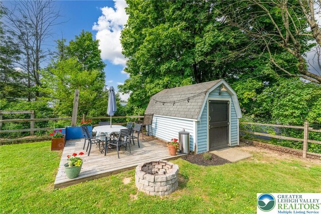 103 A St, Wind Gap Boro, PA 18091 - wooden terrace with outdoor dining area, a storage unit, a fenced backyard, and a fire pit