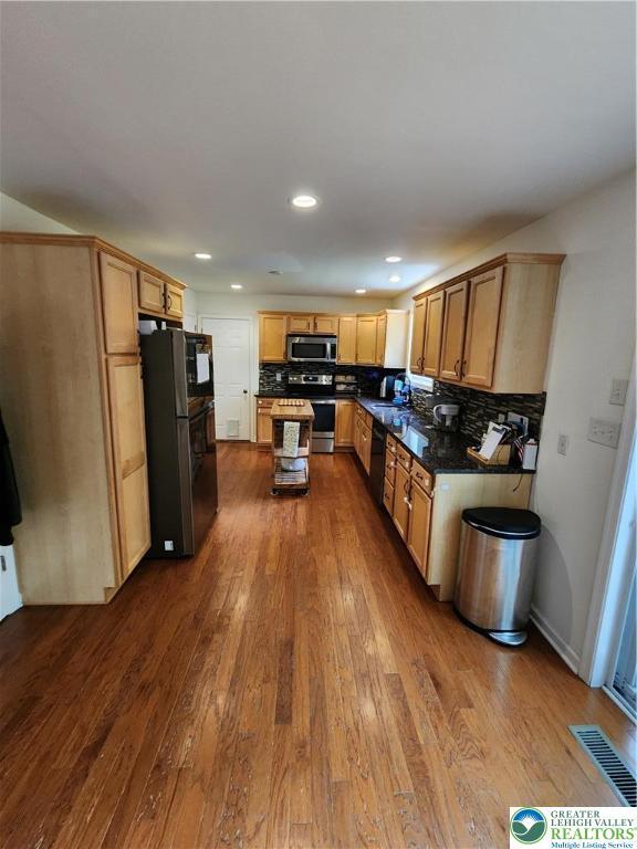 7 Twelve Oaks Trl, Chestnuthill Twp, PA 18353 - kitchen featuring black appliances, dark wood-style floors, tasteful backsplash, dark countertops, and recessed lighting