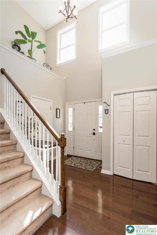 21 Millbrook Ct, Palmer Twp, PA 18045 - entrance foyer featuring a high ceiling, dark wood-style floors, stairs, healthy amount of natural light, and a chandelier