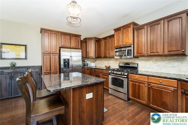 21 Millbrook Ct, Palmer Twp, PA 18045 - kitchen featuring stainless steel appliances, dark stone countertops, dark wood-style floors, a center island, and a kitchen breakfast bar