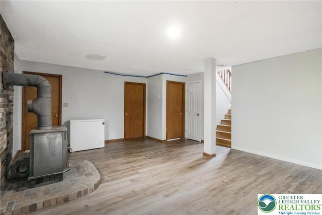 2227 Cheyenne Dr, Tunkhannock Township, PA 18610 - unfurnished living room with a wood stove, wood finished floors, and stairway