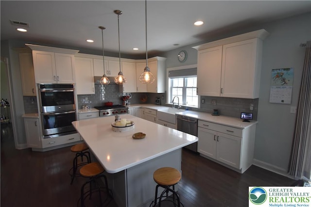 4323 Saratoga Dr, Lower Nazareth Twp, PA 18020 - kitchen with stainless steel appliances, a breakfast bar, light countertops, tasteful backsplash, and white cabinets