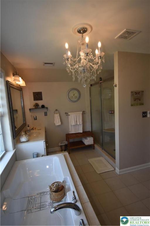 4323 Saratoga Dr, Lower Nazareth Twp, PA 18020 - bathroom with a garden tub, a shower stall, a chandelier, vanity, and tile patterned flooring