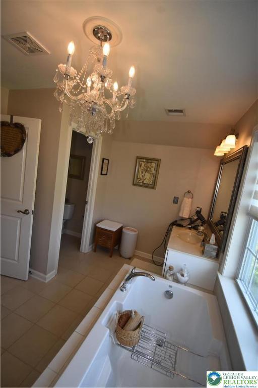 4323 Saratoga Dr, Lower Nazareth Twp, PA 18020 - full bathroom featuring a chandelier, a bath, tile patterned flooring, and vanity