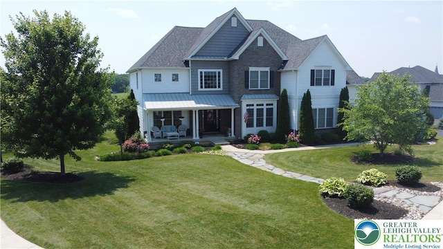 4323 Saratoga Dr, Lower Nazareth Twp, PA 18020 - view of front of property with a front yard, a standing seam roof, a shingled roof, covered porch, and a metal roof