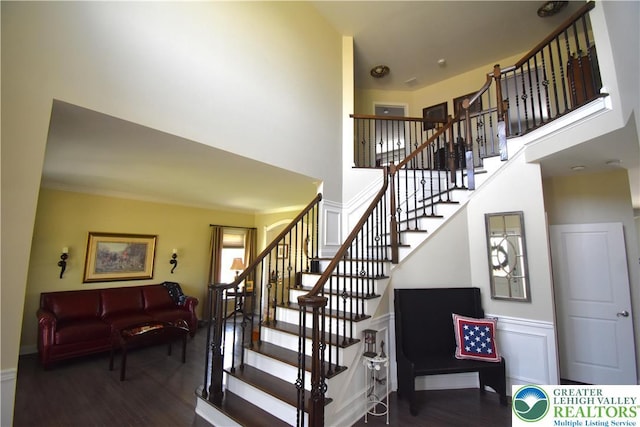 4323 Saratoga Dr, Lower Nazareth Twp, PA 18020 - stairway featuring wood finished floors, a towering ceiling, and a wainscoted wall
