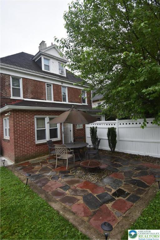 407 W Burke St, Easton, PA 18042 - rear view of house with a patio, brick siding, and a chimney