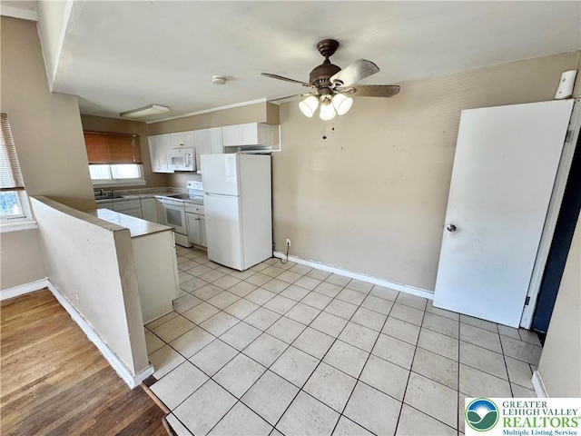 909 Genesee St, Allentown City, PA 18103 - kitchen with white appliances, white cabinets, a ceiling fan, a peninsula, and light tile patterned floors