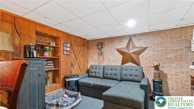 3063 Clearview St, Palmer Twp, PA 18045 - living area featuring a paneled ceiling, brick wall, built in shelves, and wooden walls