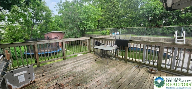 2463 Hillside Ave, Wilson Boro, PA 18042 - deck featuring a trampoline and view of wooded area