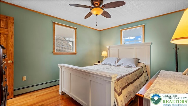 807 Bangor Rd, Plainfield Twp, PA 18064 - bedroom with baseboard heating, light wood-style floors, ornamental molding, and ceiling fan