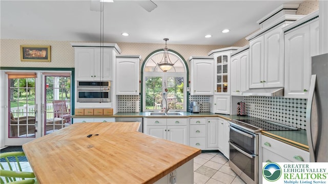 807 Bangor Rd, Plainfield Twp, PA 18064 - kitchen featuring appliances with stainless steel finishes, wood counters, white cabinets, decorative backsplash, and decorative light fixtures