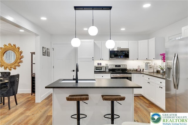 119 Tenicum Trl, Coolbaugh Twp, PA 18347 - kitchen featuring appliances with stainless steel finishes, dark countertops, light wood-style floors, white cabinets, and recessed lighting