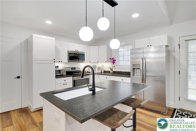119 Tenicum Trl, Coolbaugh Twp, PA 18347 - kitchen featuring stainless steel appliances, dark countertops, light wood-type flooring, a kitchen bar, and recessed lighting