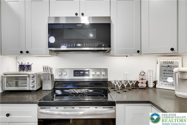 119 Tenicum Trl, Coolbaugh Twp, PA 18347 - kitchen featuring appliances with stainless steel finishes, dark countertops, and white cabinets