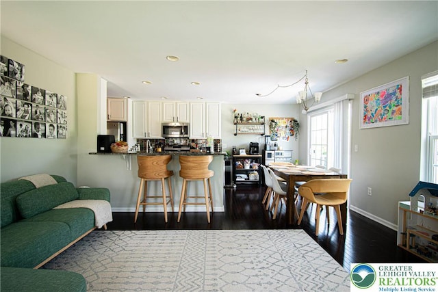 5959 Valley Forge Rd, Upper Saucon Twp, PA 18036 - kitchen featuring stainless steel appliances, dark countertops, a kitchen bar, a peninsula, and dark wood-type flooring