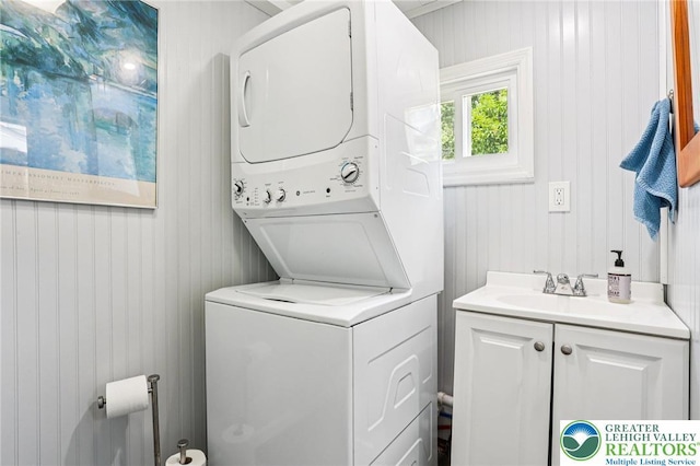 337 N 10th St, Allentown City, PA 18102 - laundry area with stacked washer and clothes dryer, cabinet space, and wooden walls