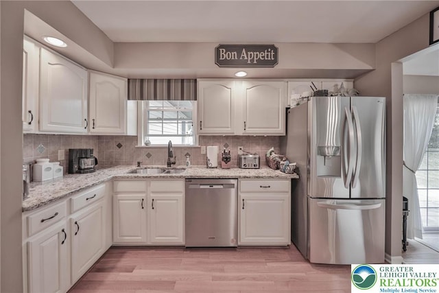 106 Fernwood Dr, Forks Twp, PA 18040 - kitchen with stainless steel appliances, white cabinets, light stone counters, tasteful backsplash, and light wood-type flooring