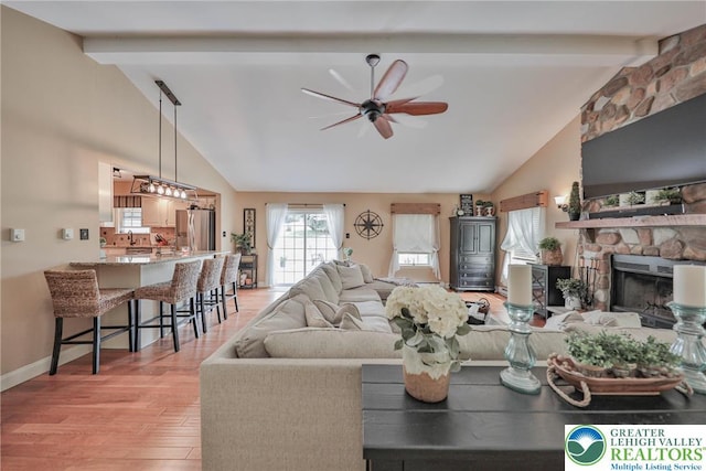 106 Fernwood Dr, Forks Twp, PA 18040 - living room featuring ceiling fan, beam ceiling, light wood-style floors, a stone fireplace, and high vaulted ceiling