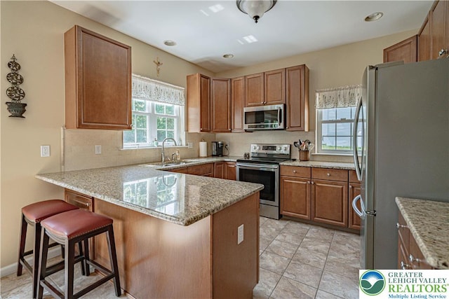3213 Overlook Dr, Lower Macungie Twp, PA 18049 - kitchen with stainless steel appliances, a peninsula, backsplash, and a kitchen breakfast bar