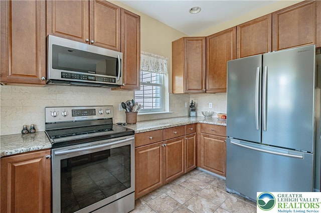 3213 Overlook Dr, Lower Macungie Twp, PA 18049 - kitchen featuring stainless steel appliances, brown cabinetry, and tasteful backsplash