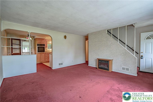 3344 Winchester Rd, Allentown City, PA 18104 - unfurnished living room featuring arched walkways, a textured ceiling, carpet flooring, and a fireplace