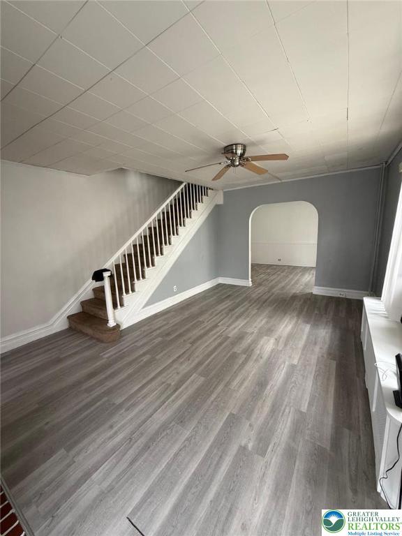 314 S Saint Cloud St, Allentown City, PA 18104 - unfurnished living room featuring arched walkways, wood finished floors, ceiling fan, and stairs